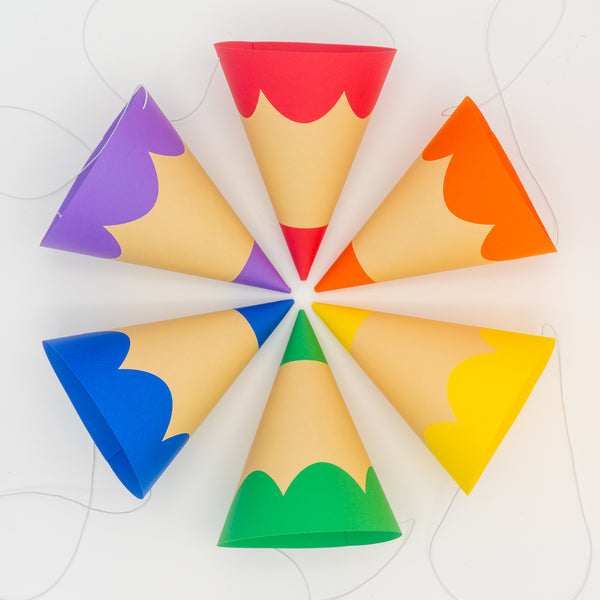 a traditional cone-shaped party hats that look just like colored pencils. The hats are arranged to look like a color wheel.