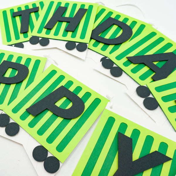 A closeup of the birthday banner fashioned to look like a green freight train. Each pennant is a cargo car with one letter on it.