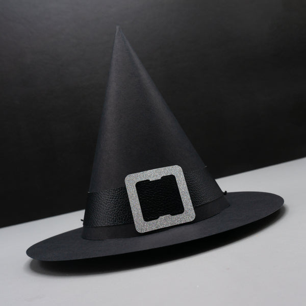 A standard cone-shaped paper party hat, resembling a witch hat. Complete with a wide brim and a buckled hat band. The hat is black with a black pleather band and a silver glittery buckle.