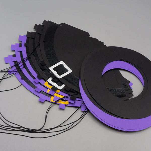 Six party hats designed to look like witch hats in purple and black. The hats are flat; not formed into cones yet. The hats are in two pieces: the cone and the brim, The cones have elastic bands and tabs for connecting to the brims.