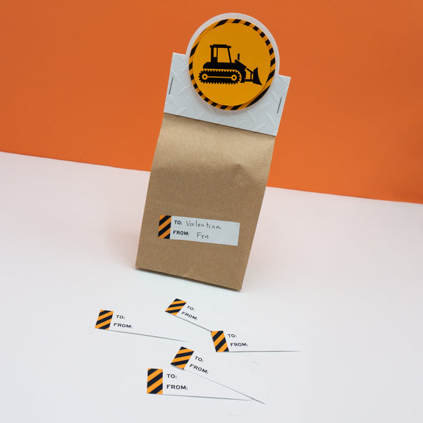 Rectangular to and from gift tag sticker labels with a black and orange warning stripe on the left side. Pictured with one on a goodie bag (sold separately).