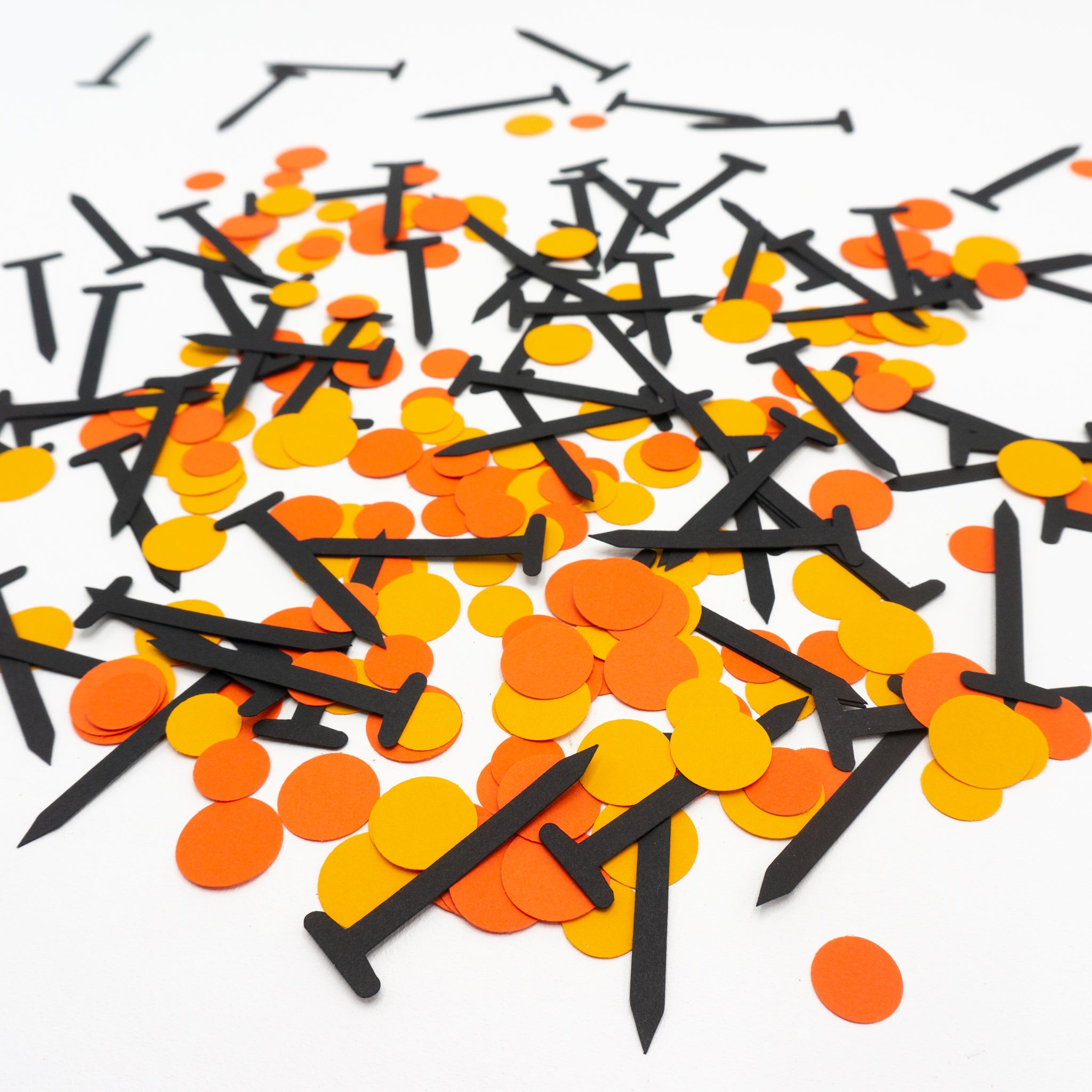 A pile of black confetti nails and orange dots