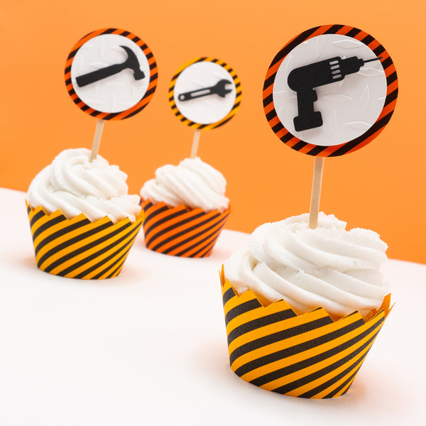 Three cupcake toppers with black tools on top of a white circle of embossed diamond plate cardstock, which is placed on top of a circle of warning stripe paper. Pictured in cupcakes with warning stripe wrappers (sold separately).